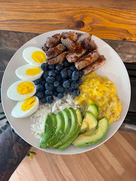 Plate with steak, eggs, blueberries and avocado